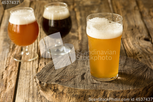 Image of Glasses of different kinds of beer on wooden background