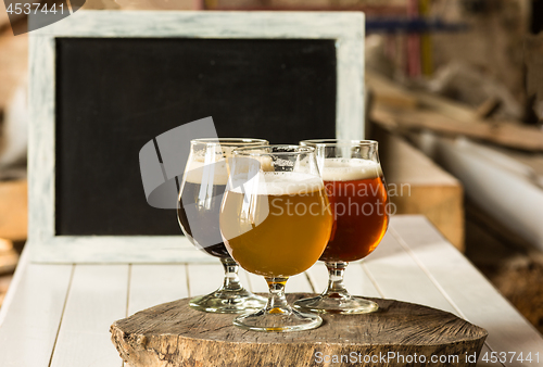 Image of Glasses of different kinds of beer on wooden background