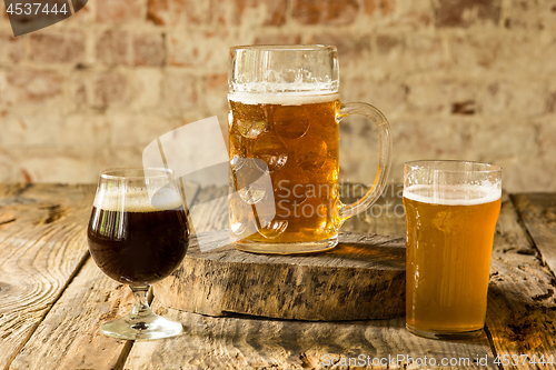 Image of Glasses of different kinds of beer on wooden background