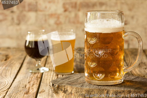 Image of Glasses of different kinds of beer on wooden background