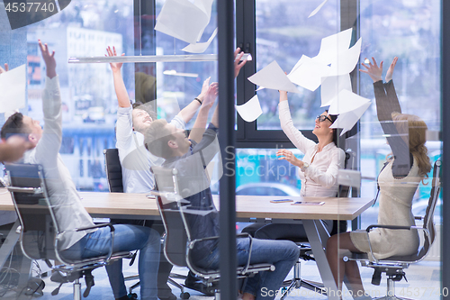 Image of startup Group of young business people throwing documents