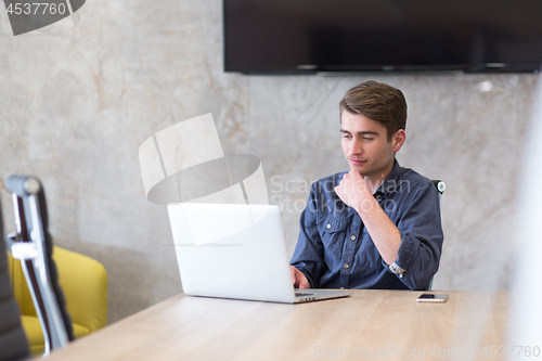 Image of businessman working using a laptop in startup office