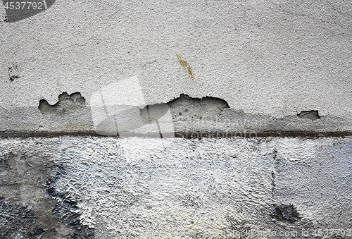 Image of cracked plaster surface on damp wall