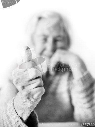 Image of Happy 96 years old elderly woman giving a thumb up and looking at camera.