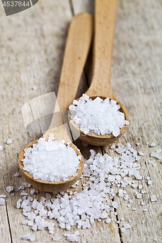 Image of Wooden spoons with sea salt closeup on wooden rustic table.