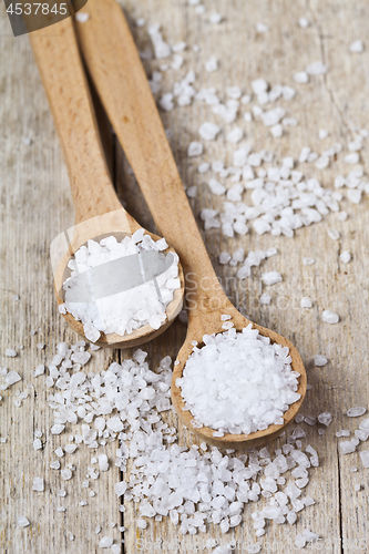 Image of Wooden spoons with sea salt closeup on wooden rustic table.