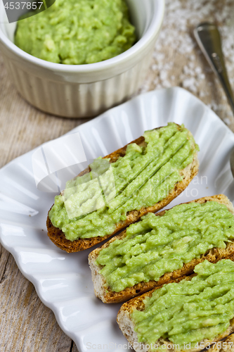 Image of Fresh crostini with avocado guacamole on white plate closeup on 