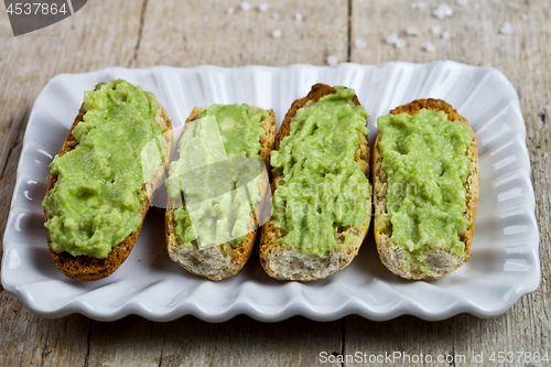 Image of Fresh crostini with avocado guacamole on white plate closeup on 