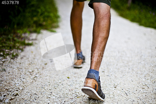 Image of Low angle ground level view with feet of a man on park or forest