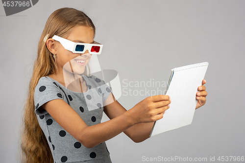 Image of The girl is looking at the colored 3D glasses made using the anaglyph technology of 3D glasses
