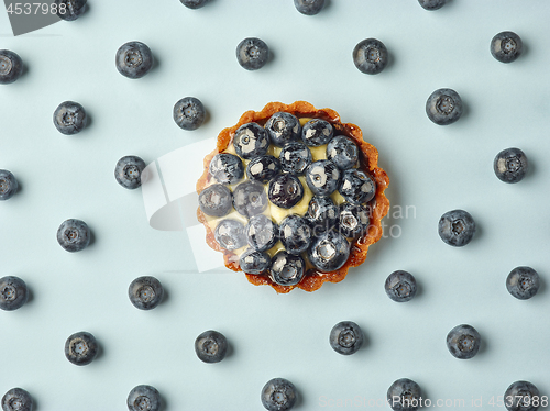 Image of blueberry tart on light blue background