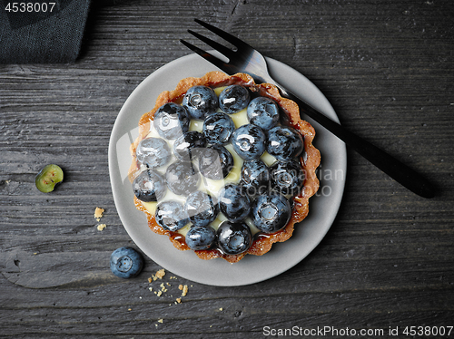 Image of blueberry tart on dark wooden table