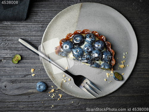 Image of blueberry tart on dark wooden table