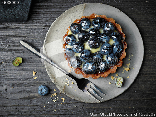 Image of blueberry tart on dark wooden table