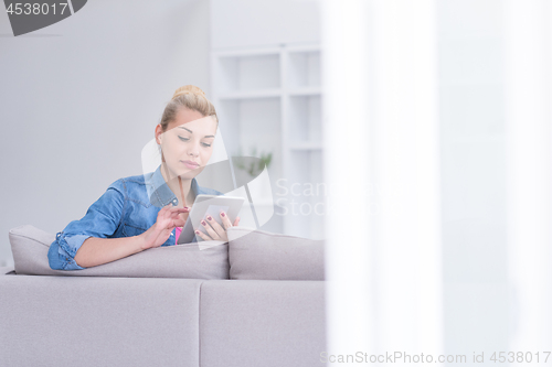 Image of woman on sofa using tablet computer