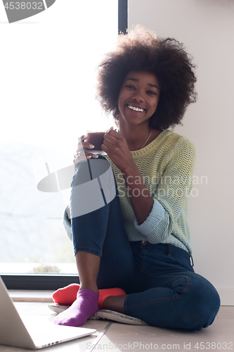 Image of black woman in the living room on the floor