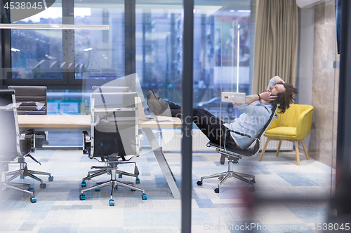 Image of young businessman relaxing at the desk