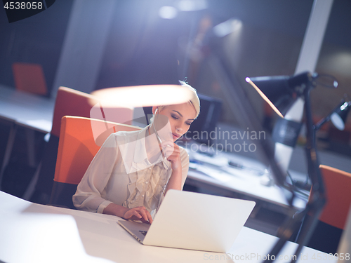 Image of woman working on laptop in night startup office