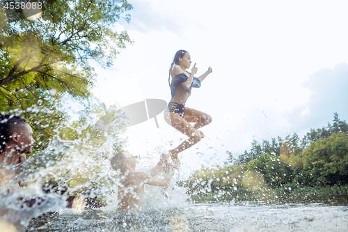 Image of Enjoying river party with friends. Group of beautiful happy young people at the river together