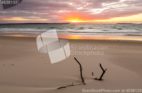 Image of Sunrise over the ocean with beautiful unspoilt beach