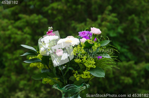 Image of Summer flowers in a decorative bouquet with a green background