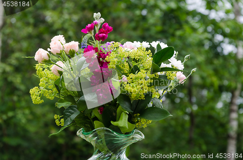 Image of Summer flowers in a bouquet with a green background outdoors