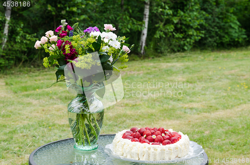 Image of Summer flowers and a strawberry cake on a table