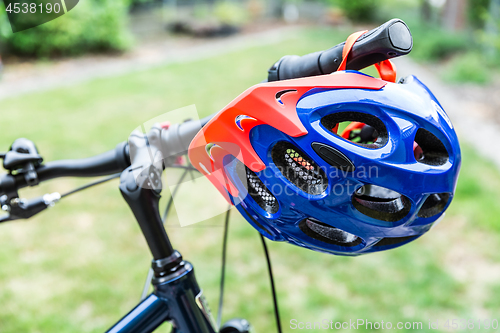 Image of Bike helmet hangs from the handlebars of a bicycle