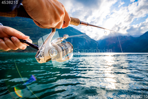 Image of Woman fishing on Fishing rod spinning in Norway.