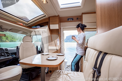 Image of Woman in the interior of a camper RV motorhome with a cup of cof