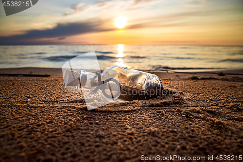 Image of Message in the bottle against the Sun setting down