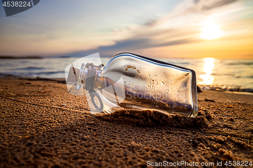 Image of Message in the bottle against the Sun setting down