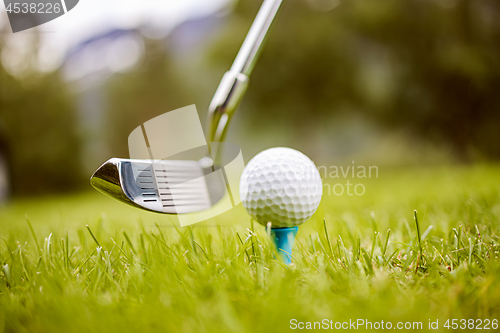 Image of Golf ball on tee in front of driver