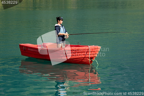 Image of Woman fishing on a boat.