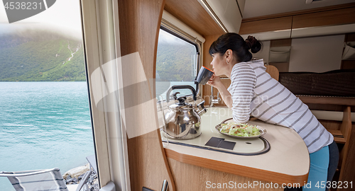 Image of Woman in the interior of a camper RV motorhome with a cup of cof