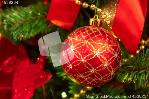 Image of Red Christmas ball hanging on Christmas tree.