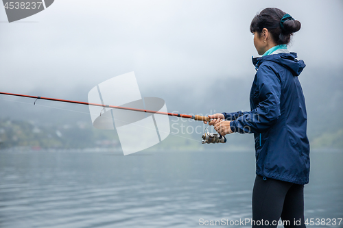 Image of Woman fishing on Fishing rod spinning in Norway.