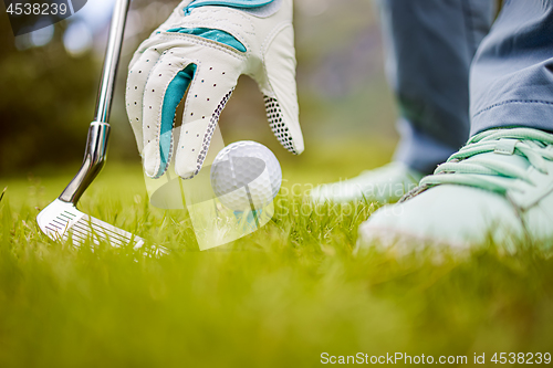 Image of Hand in glove placing golf ball on tee