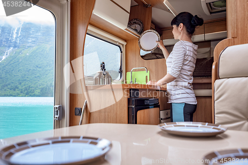 Image of Woman cooking in camper, motorhome interior