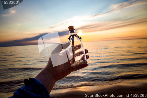 Image of Message in the bottle against the Sun setting down