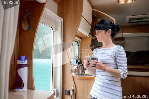 Image of Woman in the interior of a camper RV motorhome with a cup of cof