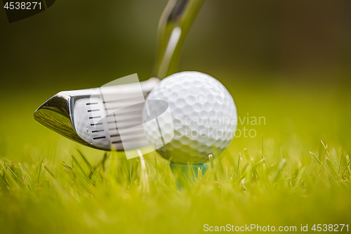 Image of Golf ball on tee in front of driver