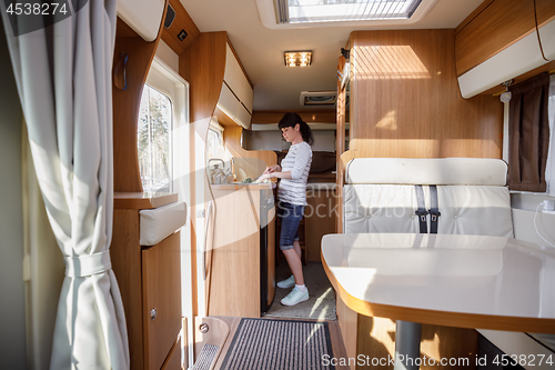 Image of Woman cooking in camper, motorhome interior