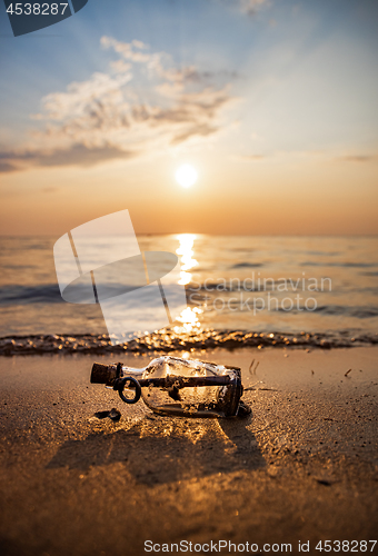 Image of Message in the bottle against the Sun setting down