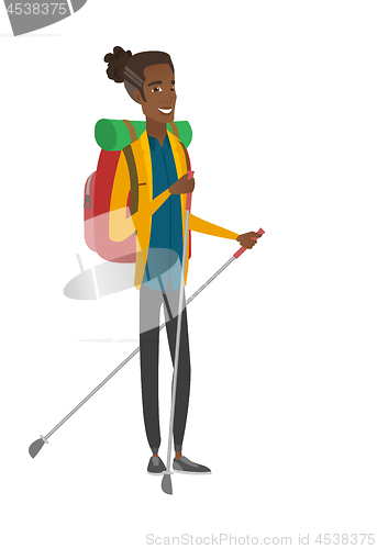 Image of Young african hiker walking with trekking sticks.
