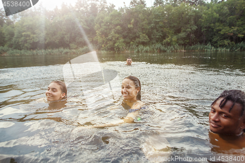 Image of Enjoying river party with friends. Group of beautiful happy young people at the river together