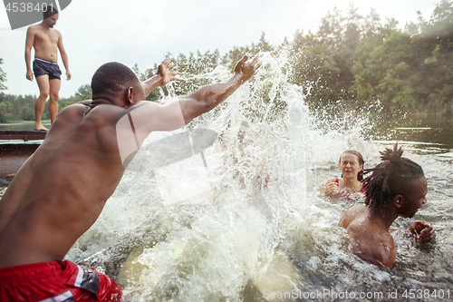 Image of Enjoying river party with friends. Group of beautiful happy young people at the river together