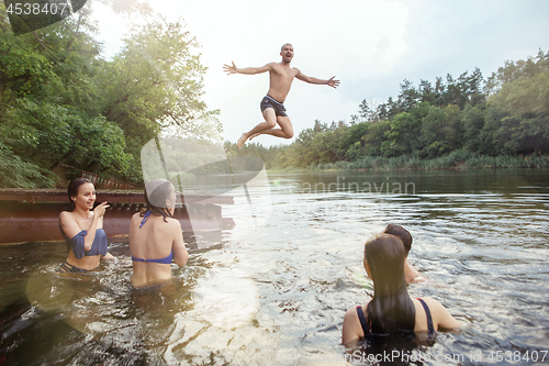 Image of Enjoying river party with friends. Group of beautiful happy young people at the river together