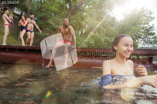 Image of Enjoying river party with friends. Group of beautiful happy young people at the river together