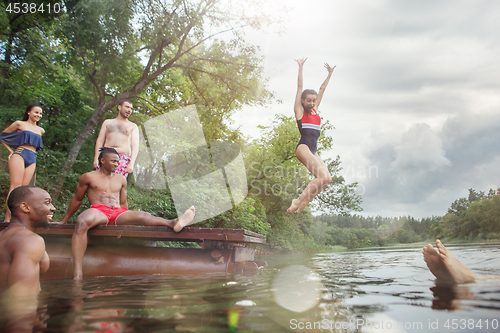 Image of Enjoying river party with friends. Group of beautiful happy young people at the river together